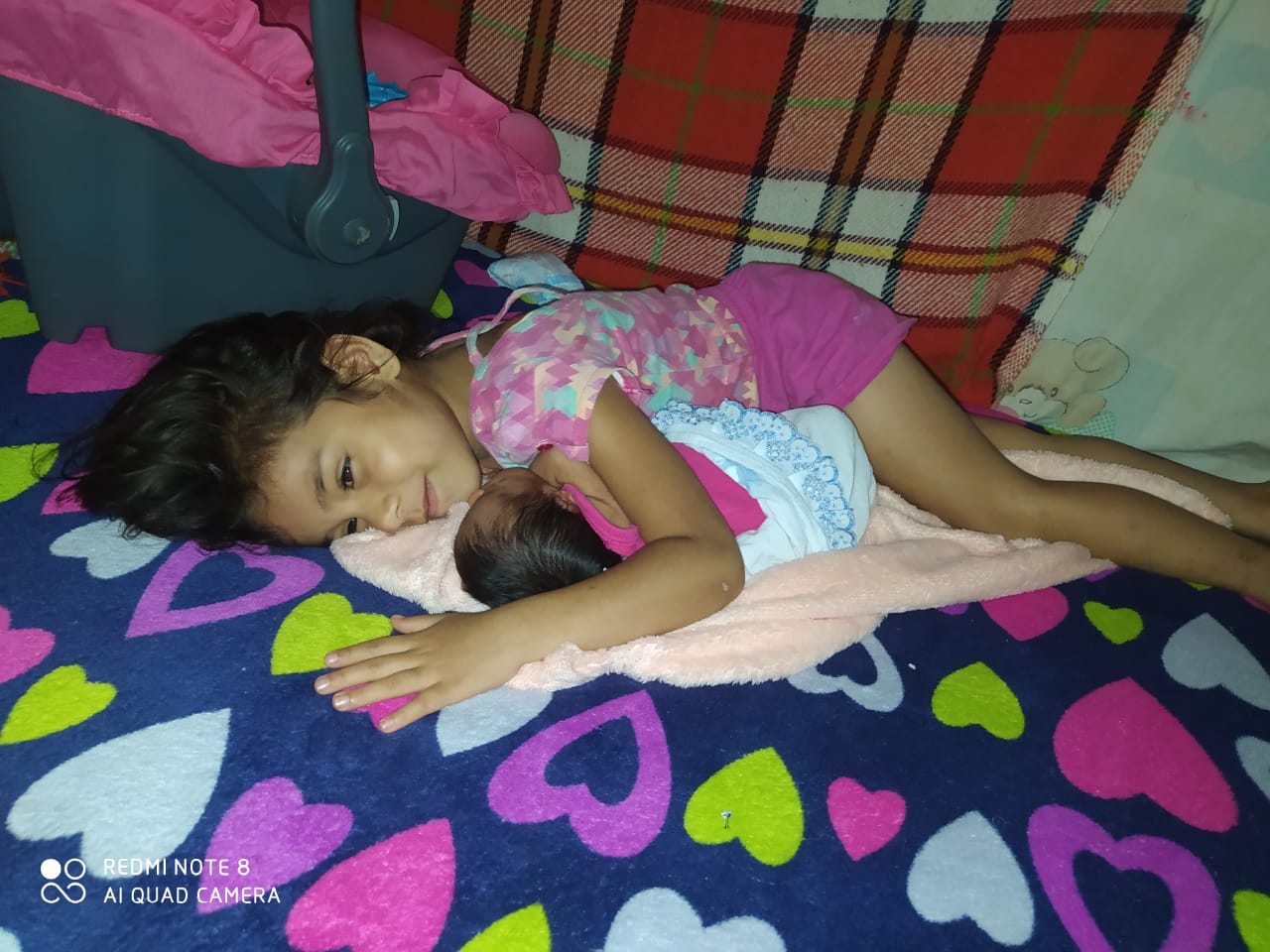 as duas irmãs deitadas, a maria clara tinha acabado de chegar da maternidade.